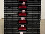 a large stack of plastic bins on a pallet in a warehouse