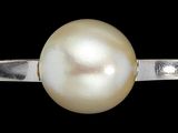 une image représentant une bague sertie d'une perle, sur fond noir