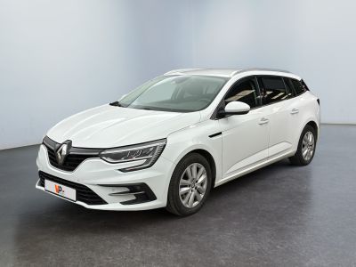 Une voiture blanche est garée dans une pièce au sol noir.
