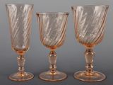 three glass goblets sitting on top of a table next to each other