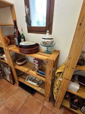 une étagère en bois sur laquelle sont posés des casseroles et des poêles, dans une cuisine