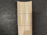 a close up of a piece of brown leather on a black surface