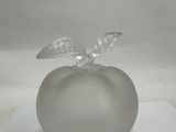 a glass apple with a leaf on top of it
