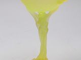 yellow glass vase on a white surface with a white background