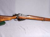 un vieux fusil en bois coiffé d'un chapeau vert sur fond blanc