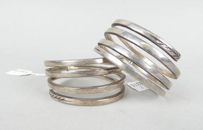 trois bagues en argent empilées les unes sur les autres sur une surface blanche