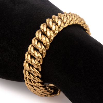 une photo en gros plan d'un bracelet en or posé sur une serviette