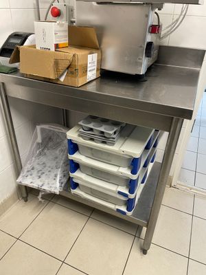 une table de travail en acier inoxydable sur laquelle sont posées plusieurs boîtes