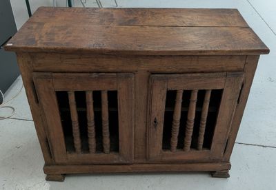 a small wooden cabinet with two doors on top of it