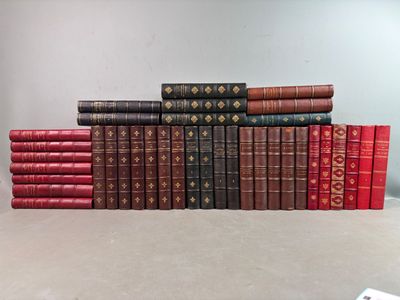 une pile de livres posée sur une table, à côté d'une télécommande