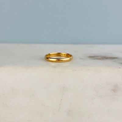 une photo d'une alliance en or posée sur une surface en marbre