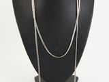 a black mannequin with a silver chain on it