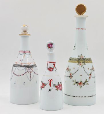 trois vases blancs, ornés de motifs et de dessins variés, posés sur un fond blanc