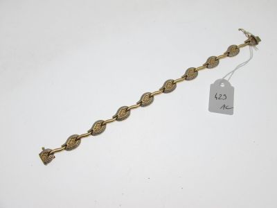 un bracelet en or sur fond blanc, avec une étiquette de prix