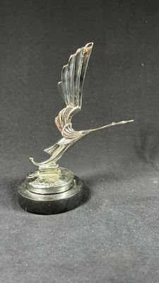 statue of a bird on a pedestal on a black background