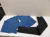 blue sweater and black pants sitting on a table in a room