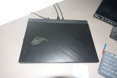 un ordinateur portable posé sur un bureau, à côté d'un clavier