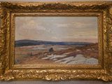 une peinture à l'huile représentant un paysage, encadrée dans un cadre doré et accrochée au mur