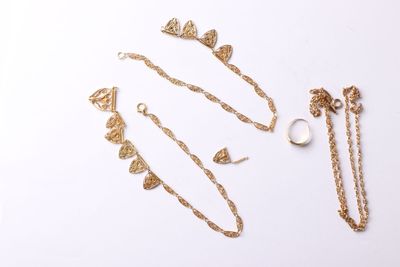three pieces of gold jewelry on a white surface