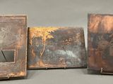 three old books are sitting on a table with a gray background