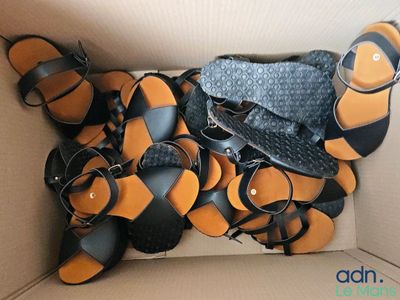 une boîte remplie de sandales, avec un sac à main à l'intérieur