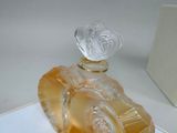 a glass perfume bottle with a heart on top of it