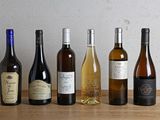 plusieurs bouteilles de vin sont alignées sur une table en bois