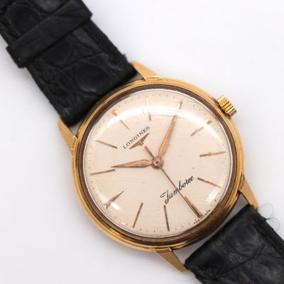 a close up of a watch on a white surface