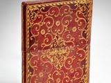 an image of a red and gold book on a white surface