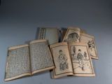 de nombreux livres anciens, portant des inscriptions en caractères asiatiques, posés sur une table