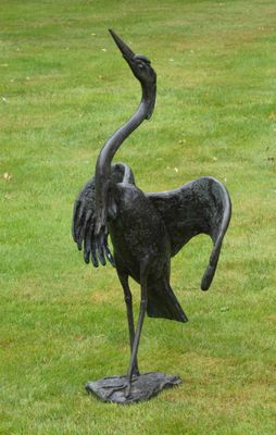 une statue représentant un oiseau, posée dans l'herbe