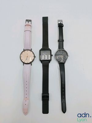 trois montres de styles différents posées côte à côte sur une surface blanche