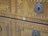 a close up of a wooden dresser with metal knobs