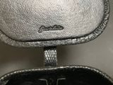 someone is holding a silver purse with a black handle
