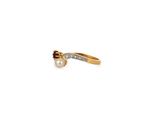 a close up of a gold ring with a pearl and a diamond