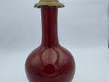 un vase rouge posé sur une table