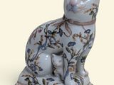 a blue and white cat figurine sitting on a stand