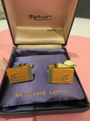 deux paires de boutons de manchette dans un coffret posé sur une table