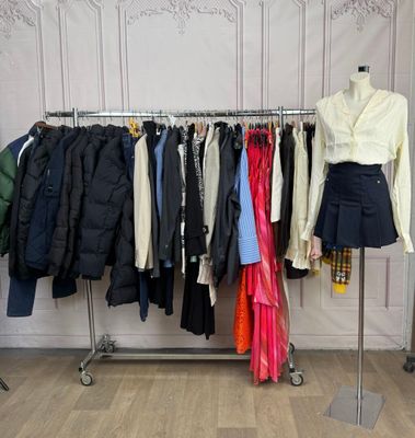 beaucoup de vêtements suspendus à une étagère dans une pièce
