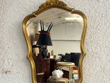 a mirror hanging on the wall with a lamp on it