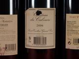 three bottles of red wine are lined up on a shelf