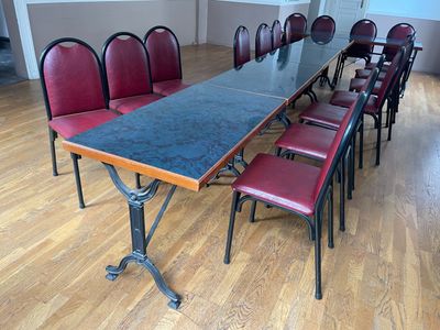 une longue table avec des chaises rouges au milieu d'une pièce