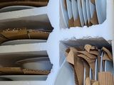 many plates and spoons stacked on a shelf in the kitchen