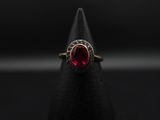 Gros plan sur une bague contenant une pierre rouge