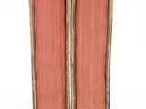 two old books sitting on top of each other on a white surface