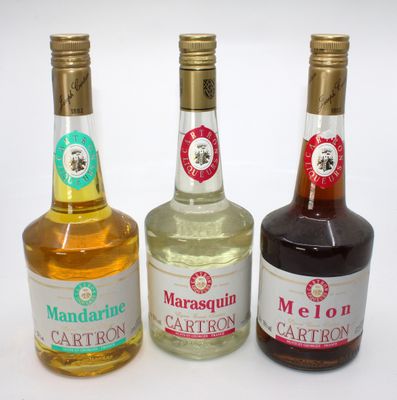 three bottles of liquor are lined up on a white surface