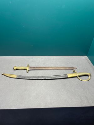 deux épées exposées dans une vitrine posée sur une table