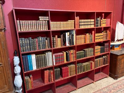 une bibliothèque rouge sur laquelle sont posés de nombreux livres