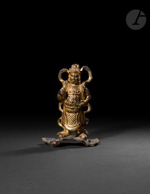 une figurine en or représentant une personne tenant un serpent