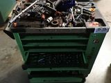 a green cart with tools on it in a garage